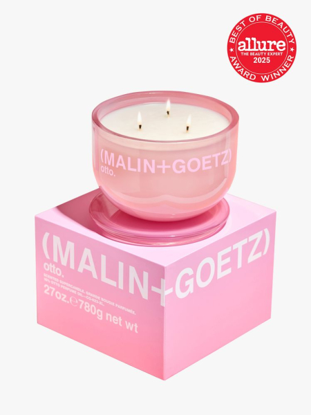 Malin & Goetz otto supercandle in clear pink container atop branded pink box packaging on light gray background with red Allure Best of Beauty seal in the top right corner